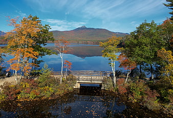 Scenic autumn landscape with lake, bridge, and mountain