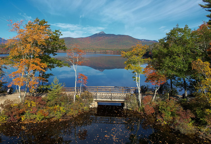 Scenic autumn landscape with lake, bridge, and mountain