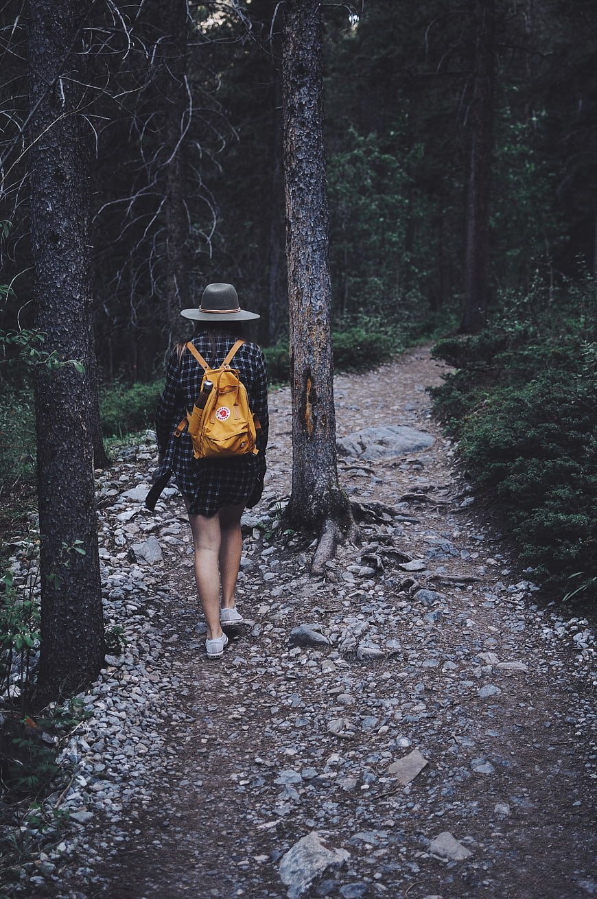 Woman Hiking on Forest Trail with Yellow Backpack