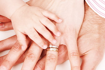 Family hands stacked together with wedding rings