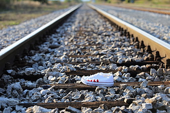 Bloody white sneaker on railway tracks symbolizing teen suicide