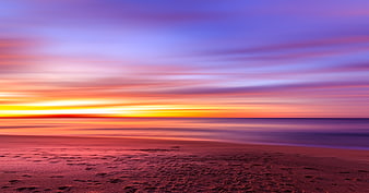 Vibrant Sunset Over Smooth Ocean Beach