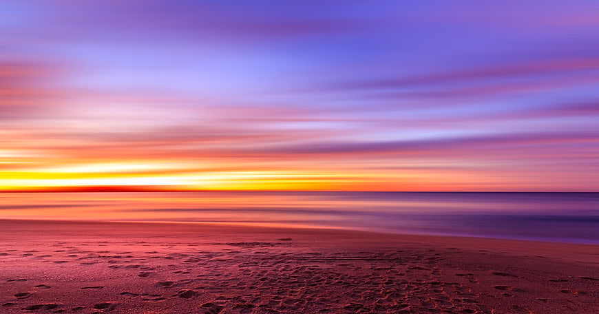 Vibrant Sunset Over Smooth Ocean Beach