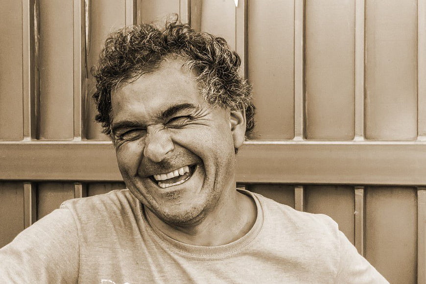 Happy Man Laughing with Curly Hair in Sepia Tone
