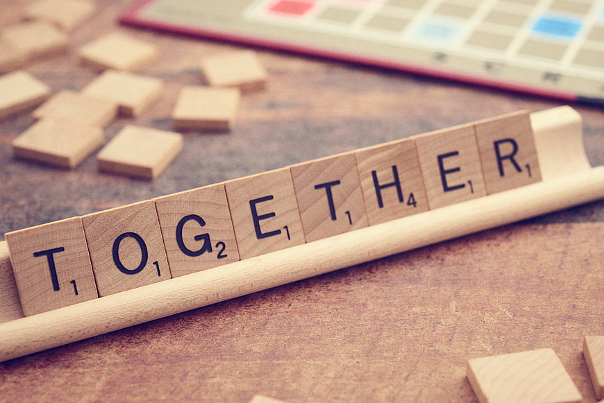 Scrabble Tiles Spelling Together on Wooden Rack