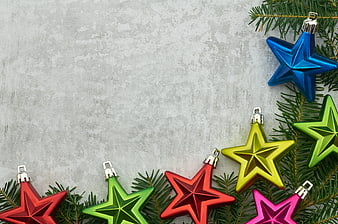 Colorful Star Christmas Ornaments on Pine Branches with Copyspace