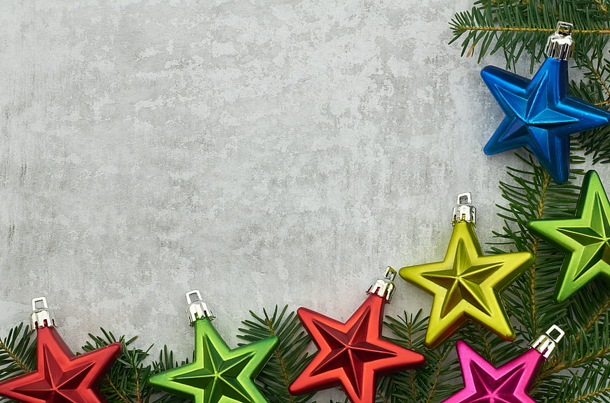 Colorful Star Christmas Ornaments on Pine Branches with Copyspace