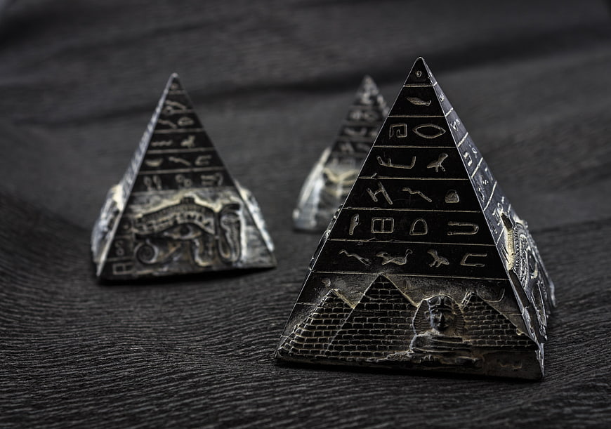 Antique Egyptian Pyramid Souvenirs on Dark Wood Surface