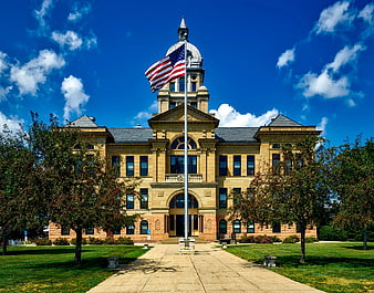 Grand historic courthouse with American flag and blue sky