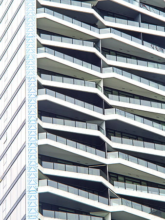Modern zigzag building facade with glass balconies