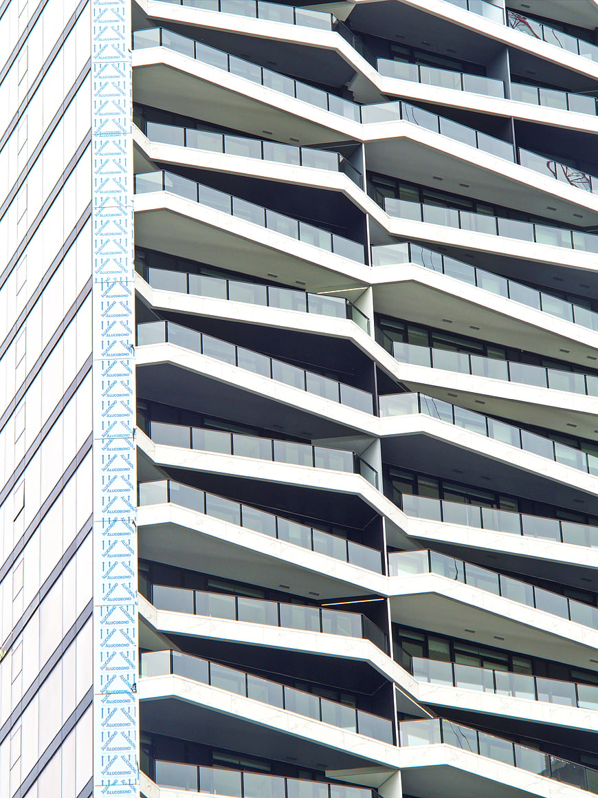 Modern zigzag building facade with glass balconies