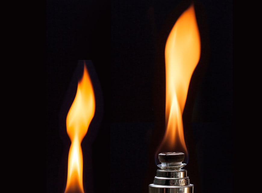 Close-up of burning oil lamp flame on black background