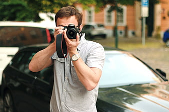 Man Taking Photo with DSLR Camera Beside Car