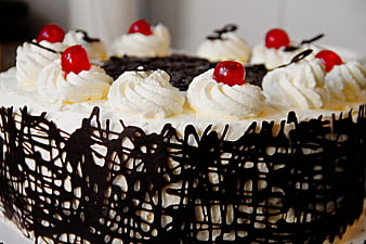 Chocolate cake with whipped cream, cherries, and chocolate lattice