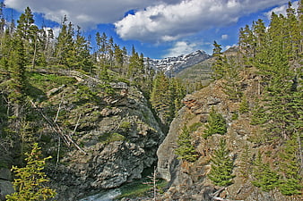 Scenic mountain canyon with wooden bridge and river