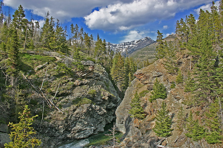 Scenic mountain canyon with wooden bridge and river