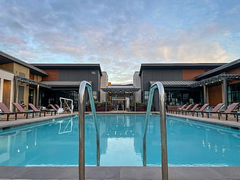 Modern Resort Swimming Pool With Loungers And Sky