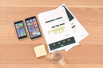 Business analytics report with smartphones on wooden desk