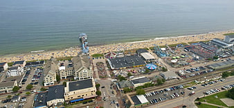 Aerial view of busy beach town with amusement park and pier