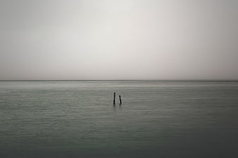 Minimalist Misty Sea Horizon With Two Wooden Posts