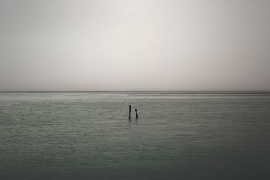 Minimalist Misty Sea Horizon With Two Wooden Posts