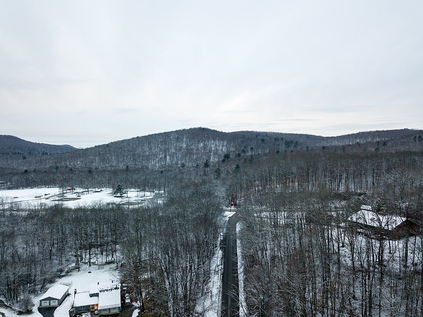 Aerial view of snowy forest road and winter landscape