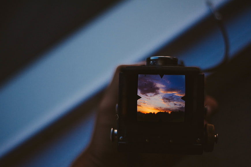 Vintage Rangefinder Camera Framing a Dramatic Sunset Sky