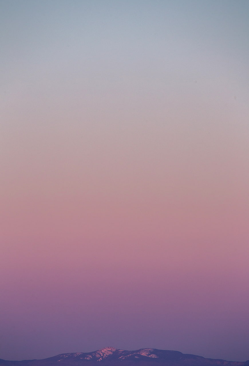 Minimalist Pink and Purple Sky Gradient Over Snowy Mountain Peak