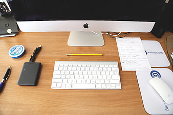 Organized wooden desk with iMac, keyboard, and office supplies