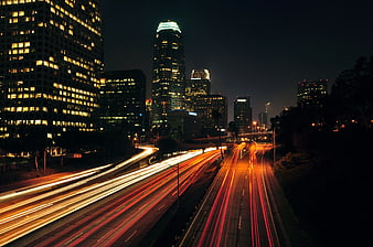 Nighttime cityscape with long exposure light trails on highway