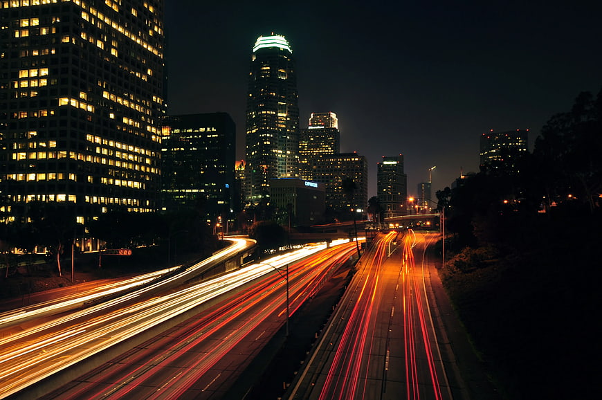 Nighttime cityscape with long exposure light trails on highway