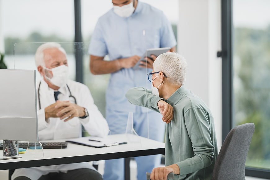 Senior patient coughing during doctor consultation with nurse