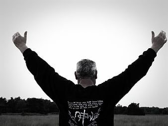 Man with arms raised in worship in black and white