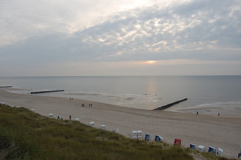 Wide View of North Sea Beach with Wooden Beach Chairs at Sunset