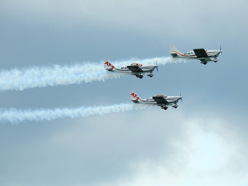 Three Aerobatic Planes Flying in Formation with Smoke Trails