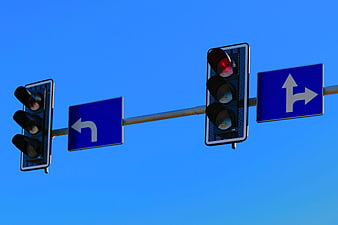 Traffic Lights and Directional Signs Against Blue Sky