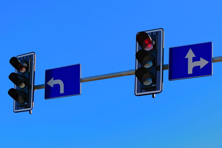 Traffic Lights and Directional Signs Against Blue Sky