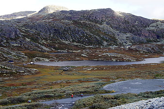 Hikers on a mountain trail in a Norwegian landscape