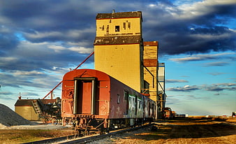 Vintage red train car parked at abandoned grain elevator