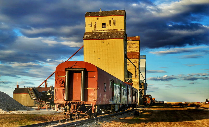 Vintage red train car parked at abandoned grain elevator