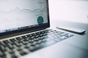 Laptop displaying analytics dashboard with smartphone