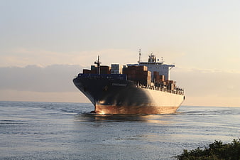 Large Cargo Ship Sailing on Calm Sea at Sunset