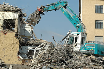 Excavator Demolishing Old Building With Rebar Debris
