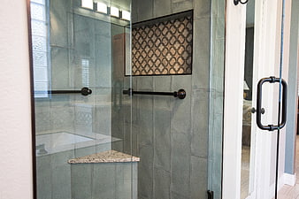 Modern bathroom shower with gray tiles and glass door