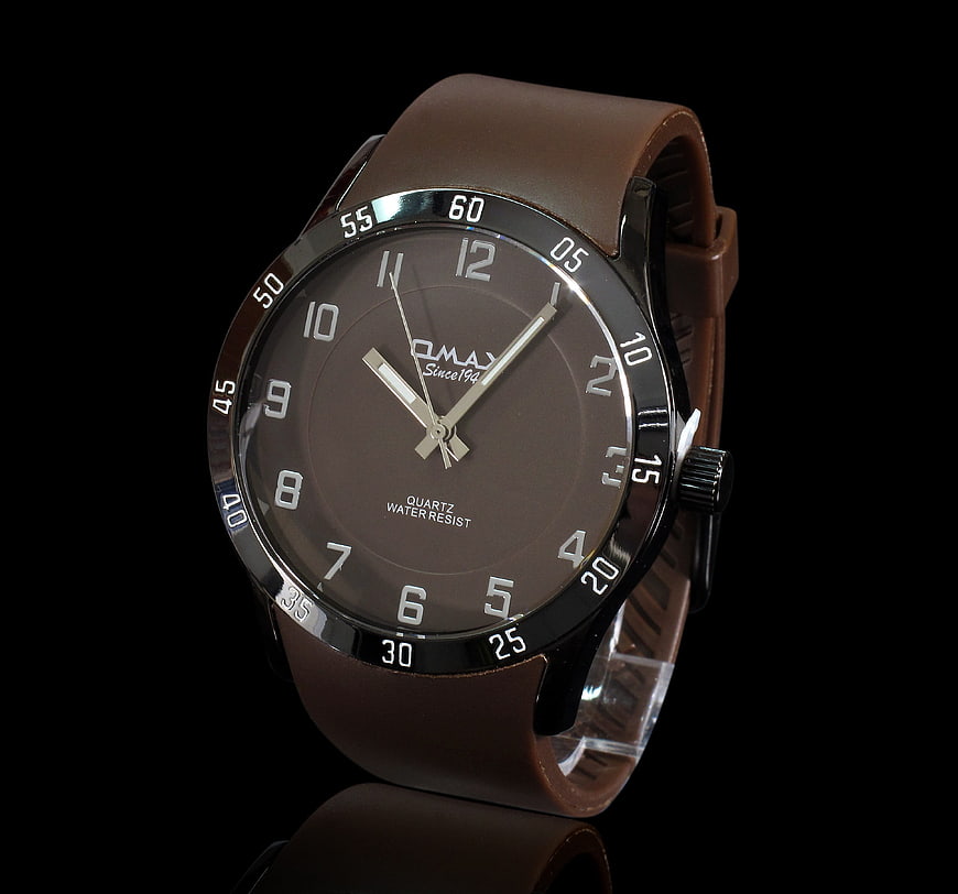 Brown leather strap wristwatch on black background