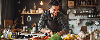 Happy Chef Cooking with Fresh Vegetables in Kitchen