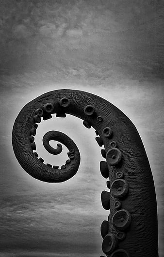 Black and white spiral dragon tail sculpture against cloudy sky