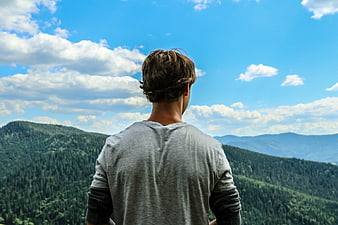 Young Man Looking at Mountain Landscape from Behind