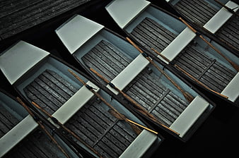 Top view of wooden boats with oars docked in dark water