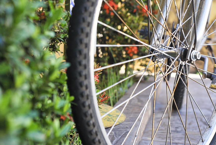 Close-up of bicycle wheel with garden background